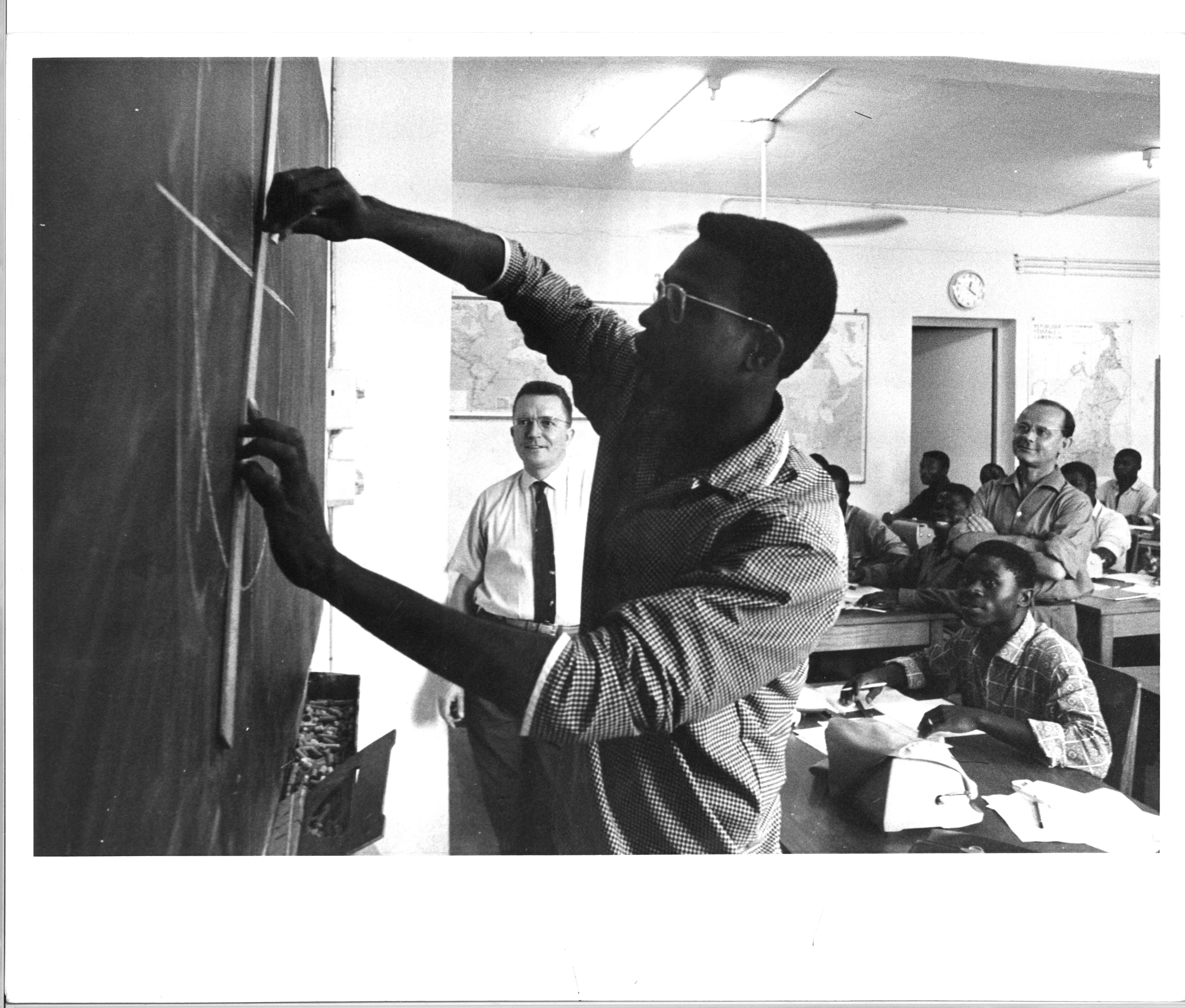 The Central Africa Training Centre on Statistics at Yaoundé, Cameroon, February 1964. A middle level training centre established to promote statistical development for French-speaking African countries. A student in training on the use of graphics by the instructor, Marcel Nenert (left) of the French Technical Assistance organization The Central Africa Training Centre on Statistics at Yaoundé, Cameroon, February 1964. A middle level training centre established to promote statistical development for French-speaking African countries. A student in training on the use of graphics by the instructor, Marcel Nenert (left) of the French Technical Assistance organization